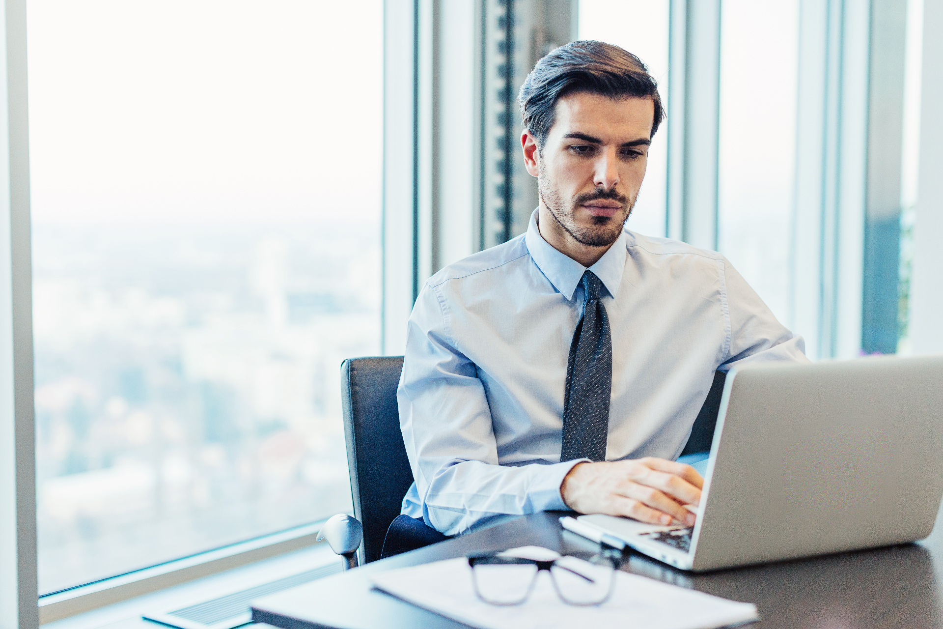 Compliance leader reviewing an obligations register on a laptop