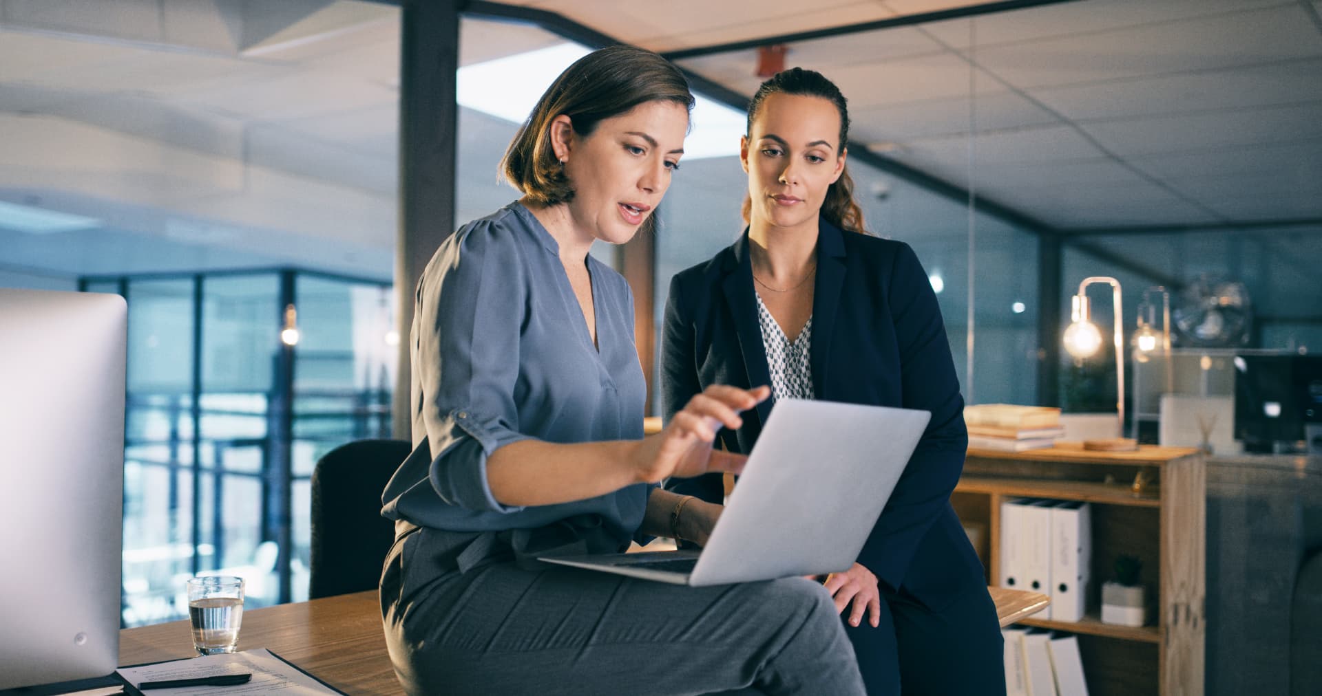 Two workplace professionals reviewing material on a laptop