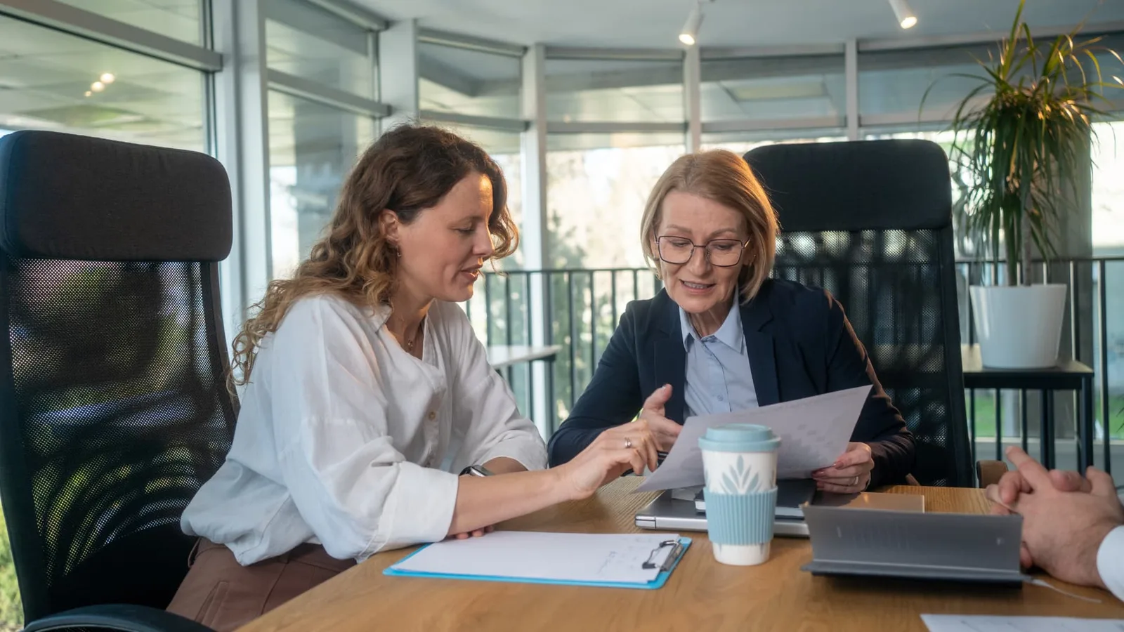 Employer and workplace adviser reviewing documents in a professional office